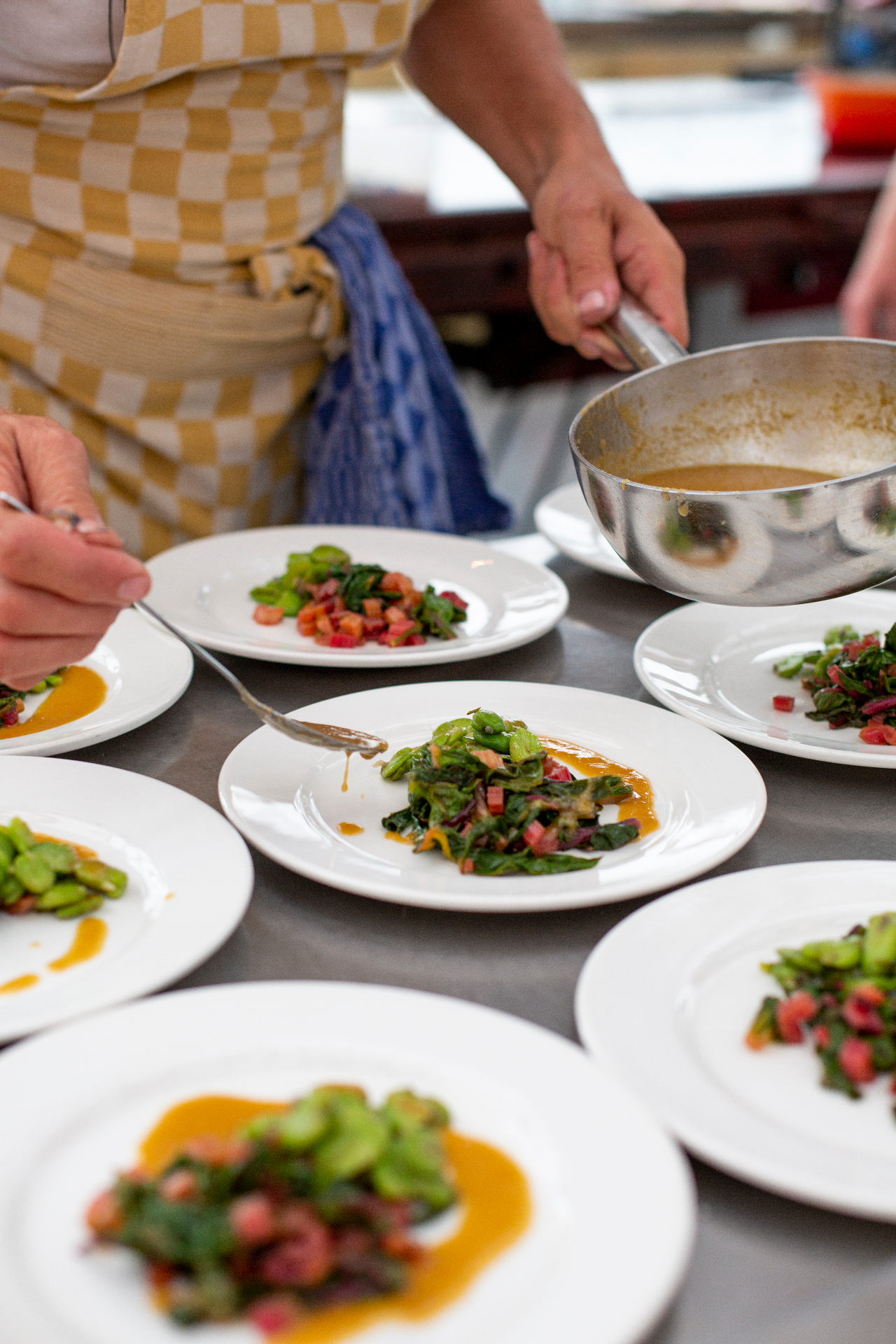 Handen van de chef die een gerecht opmaakt